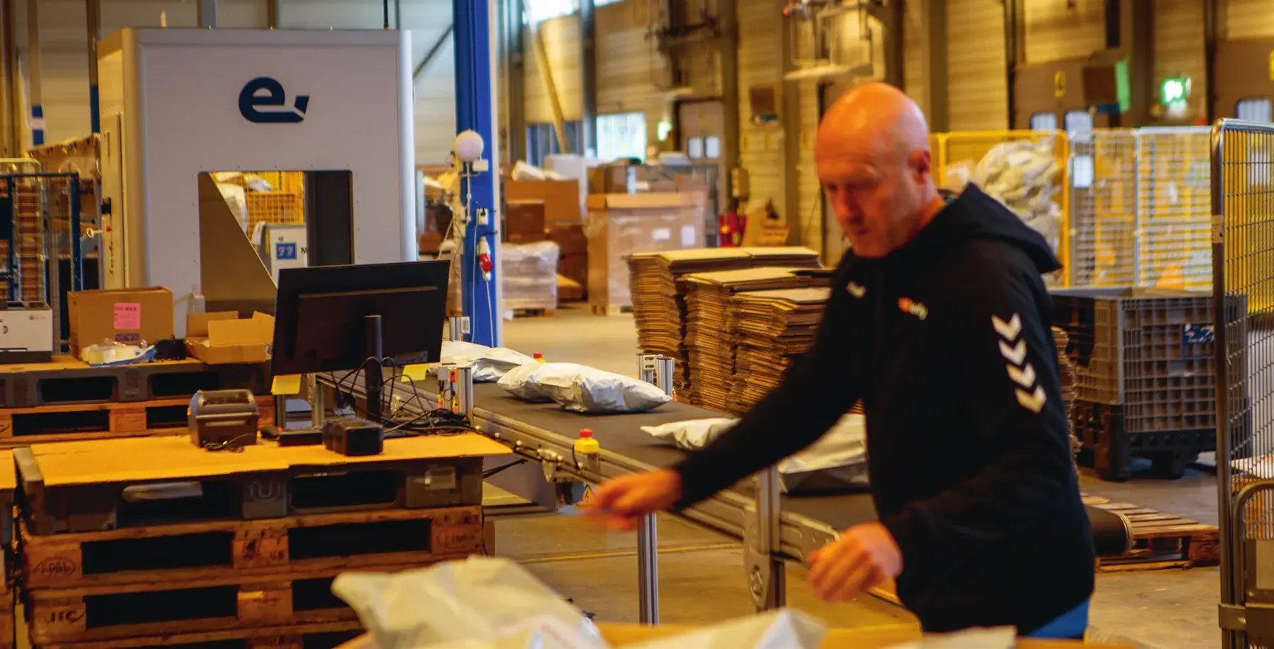 Warehouse employee scanning goods at a packing station at Spedify in Askim